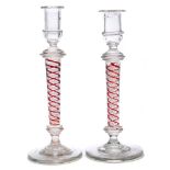 A close pair of glass two colour opaque twist glass candlesticks: each with clear nozzle and drip