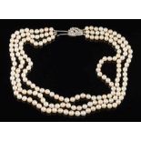 A graduated cultured pearl three-string necklace: with diamond mounted foliate cluster clasp.