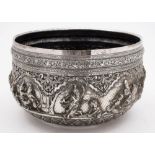 A large Indian silver bowl: of circular form, with banded decoration of mythical figures, hunters,