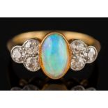 An 18ct gold, opal and diamond seven stone ring: the central oval opal approximately 9.2mm long x 5.