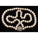 A cultured pearl two-string necklace: with diamond mounted flower head cluster clasp.