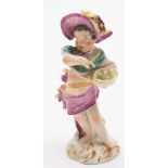 An 18th century German porcelain figure of a putto emblematic of Summer: holding a bird's nest with