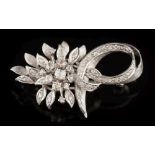 A diamond mounted floral spray brooch: of leaf and ribbon scroll design with circular brilliant-cut