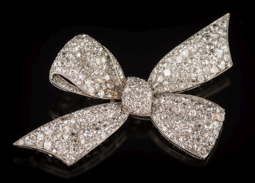 A 1930's diamond encrusted 'bow' brooch: pave-set with circular, old brilliant-cut diamonds,