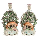 A pair of Derby porcelain fox and hen candlesticks: modelled with a seated fox devouring a hapless