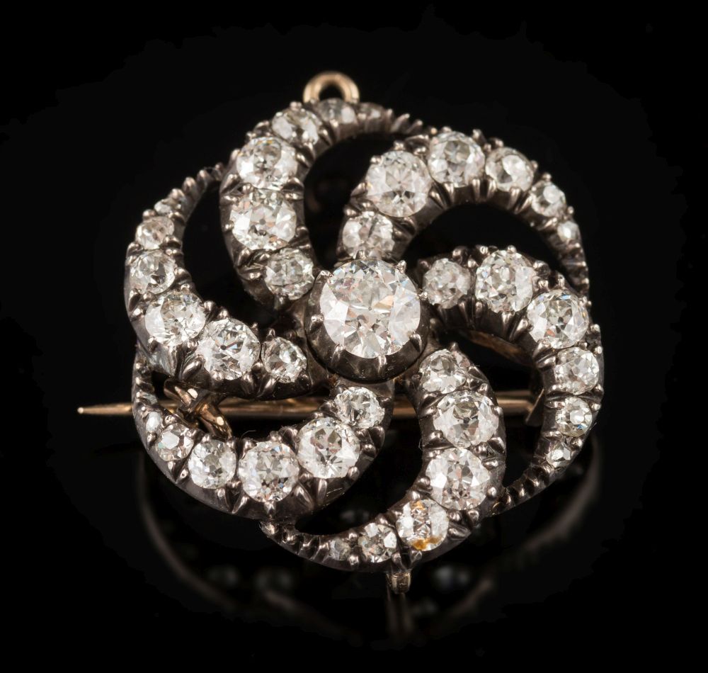 A late 19th century gold, silver and diamond circular brooch pendant: of 'Catherine Wheel' design,