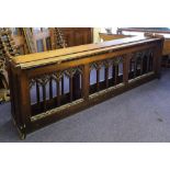 A pair of early 20th century carved oak pew fronts in the Gothic style:, 277cm long x 90cm high.