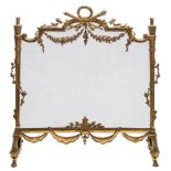 A French gilt brass fire screen:, surmounted by a laurel leaf garland,