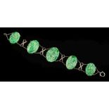 A carved and pierced jade oval panel-link bracelet: the largest panel 30mm long x 20mm wide and on