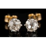 A pair of diamond single-stone ear studs: each with an irregular cushion-shaped old brilliant-cut