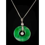 A jade disc and diamond pendant: the jade disc 26mm diameter with two round diamonds and smaller