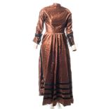 A late Victorian brown silk dress:, with rounded collar and pleated button front,