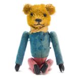 An early 20th century blonde plush clockwork tumbling Teddy bear:, with boot button eyes,