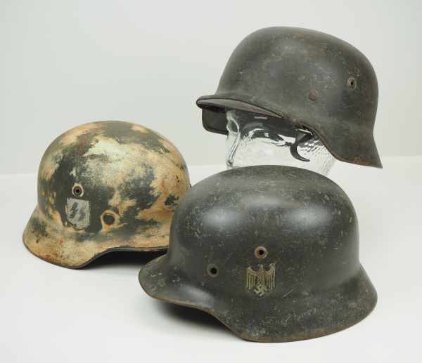 4.1.) Uniformen / Kopfbedeckungen Wehrmacht: 3 Stahlhelme.Alle Helme jeweils überarbeitet.Zustand: