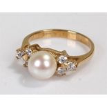 9 carat gold pearl ring, the central pearl flanked by three cubic zirconia to either side, ring size