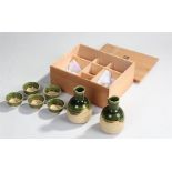 Japanese cased pottery Sake set, consisting of two bottles and five bowls, cased