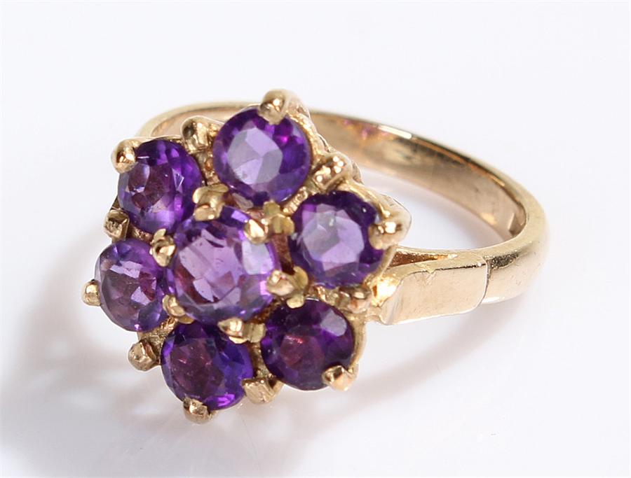 9 carat gold ring, set with purple stones to form a flower head, ring size Q