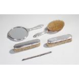 Silver vanity set, to include three brushes a comb bar and a mirror, (5)