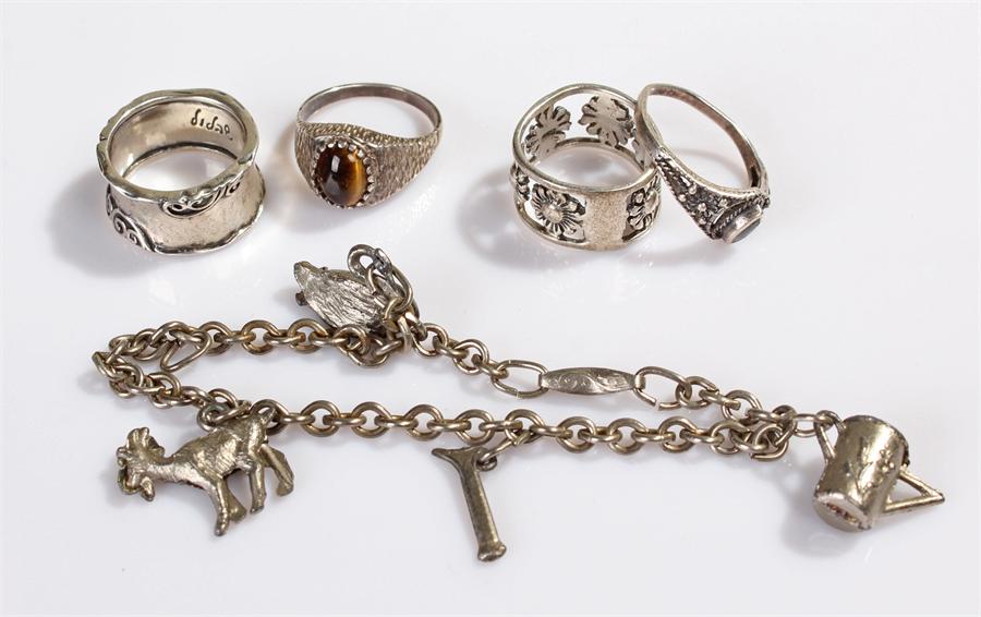 Silver jewellery, to include four silver rings and a silver charm bracelet, (5)