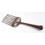 Early 19th Century cast iron fork, of large proportions, the tapering handle with bulbous end,