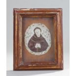 French 19th Century glass picture, of a saint with arms folded, housed within a gilt gesso frame,