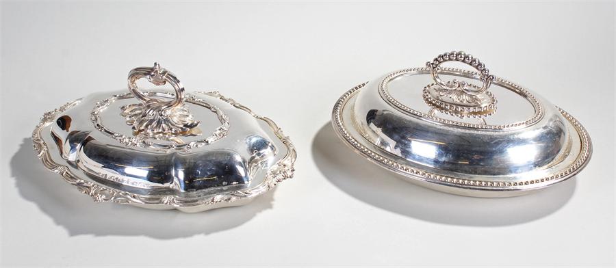 Two silver plated entrée dishes, the first with acanthus leaf arch handle above a lid with monogram,