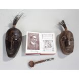 Two African masks, together with a spoon and a book by Albert Lloyd Uganda to Khartoum, (4)