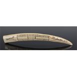 Earry 20th Century Eskimo scrimshaw tusk cribbage board, the walrus tusk centred on one side by a