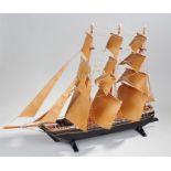 Painted model of a ship, the three mast ship with black hull decorated in gilt bands, 83cm long