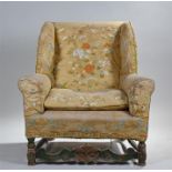 George I style wing back armchair, the stuff over upholstered back, seat and arms above green