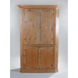 19th Century pine corner cabinet, the concave cornice above a pair of panel cupboard doors and