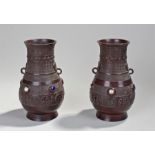 Pair of Chinese bronze vases. The vases with geometric design above loop handle and porcelain