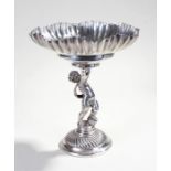 French white metal table centrepiece, the shaped bowl with gadrooned centre above a figure of a