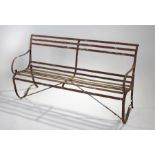 19th Century wrought iron garden bench, the bar back above a conforming seat on arched supports,