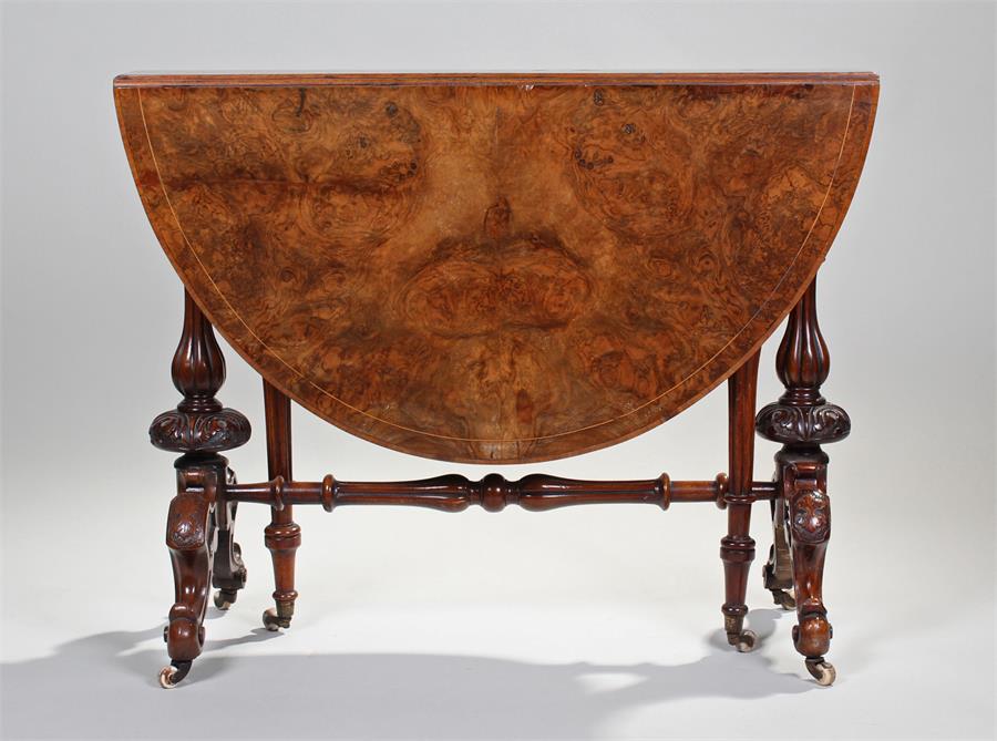 Victorian walnut drop leaf table, the oval top above turned supports and scroll cabriole legs,