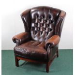 George III style wing back armchair, the stuff over back and seat raised on square section legs