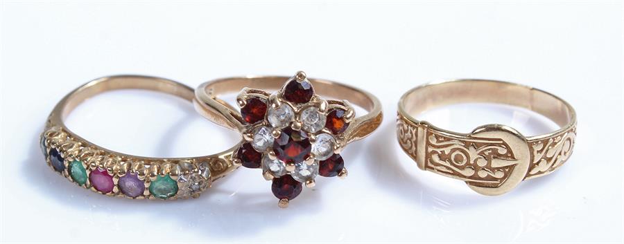 9 carat gold rings, to include a flower head example, a multi stone example and a belt type, (3)