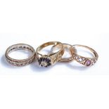 9 carat gold rings, to include an eternity ring, a band, a chequer example and a sapphire flower