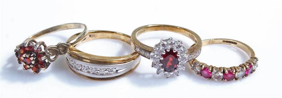 9 carat gold rings, to include two flower examples, a band and a stone set example, (4)