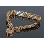 9 carat gold padlock bracelet, the bracelet with long and short links terminating with a padlock