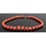 Coral necklace, with a graduated row of leaf carved spheres and a 9 carat gold clasp, 46cm long,