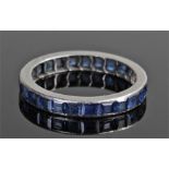 White metal sapphire eternity ring, set with a row of square cut sapphires, ring size O 1/2