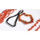 Collection of necklaces, to include two coral twig examples, a Whitby Jet example and an amber