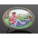 Early 20th Century enamel and silver brooch, the enamel brooch depicting a reclining lady and a