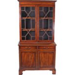 Mahogany bookcase cabinet, in the George III taste, the concave cornice above an astragal glazed