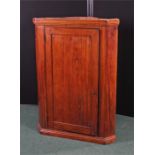 19th Century oak and elm hanging corner cabinet, the panel door enclosing a shaped shelved interior