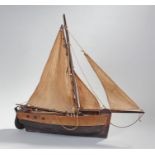 Early 20th Century pond yacht, with fabric sails above the wooden hull, 59cm long