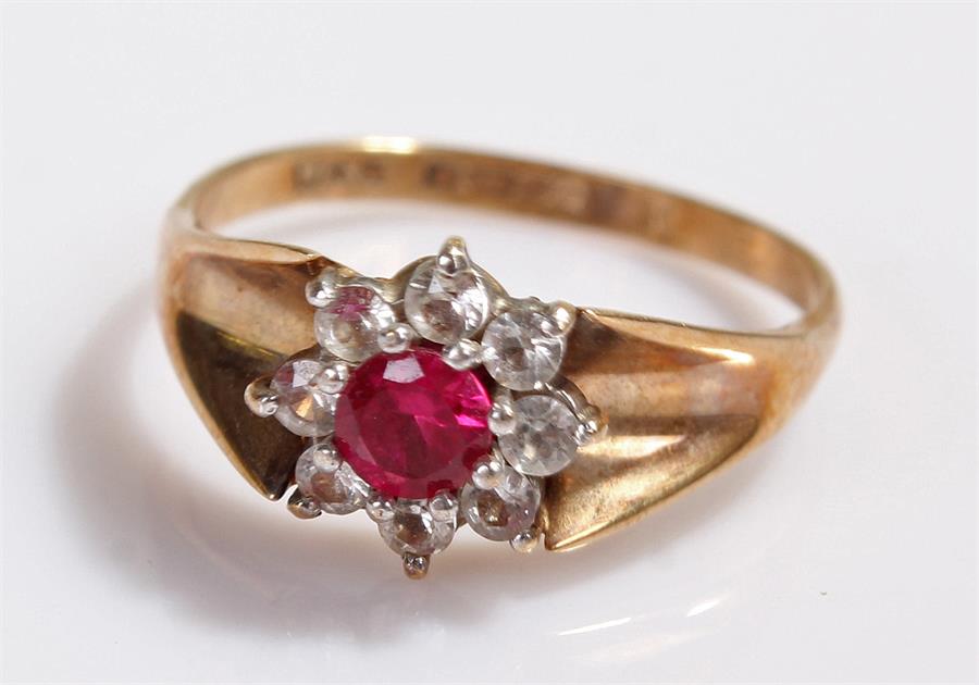 9 carat gold ring, with a flower head, red stone to the centre, 2.8 grams