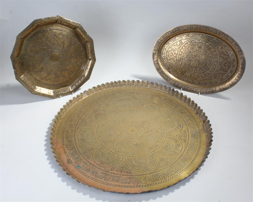 Three Middle Eastern brass dishes with geometric patterns, one oval and two circular, diameters: