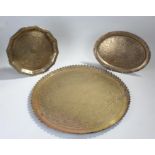 Three Middle Eastern brass dishes with geometric patterns, one oval and two circular, diameters: